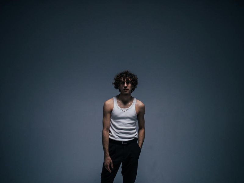 Man in a focused pose in a minimalist dark room.
